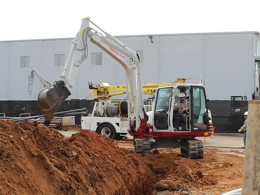 Open utility trench with pipe being installed